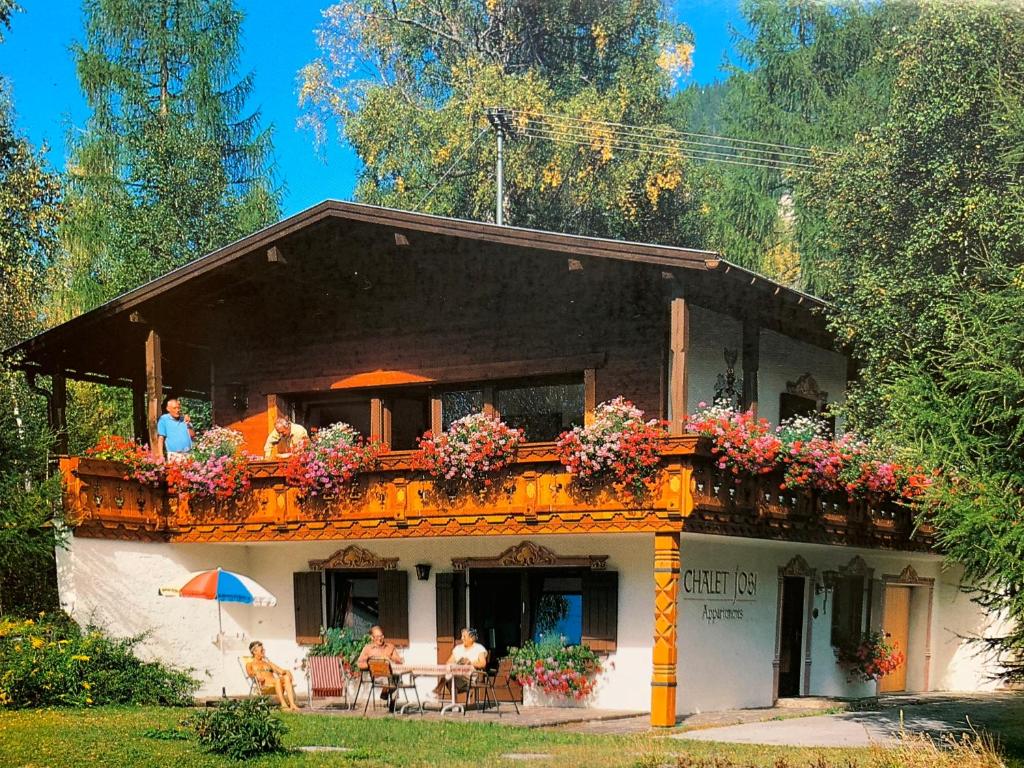 ein Haus mit Menschen auf einem Balkon in der Unterkunft Chalet Josi in Leutasch