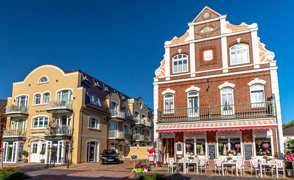 un gruppo di edifici con una torre dell'orologio su una strada di La Maison M a Westerland