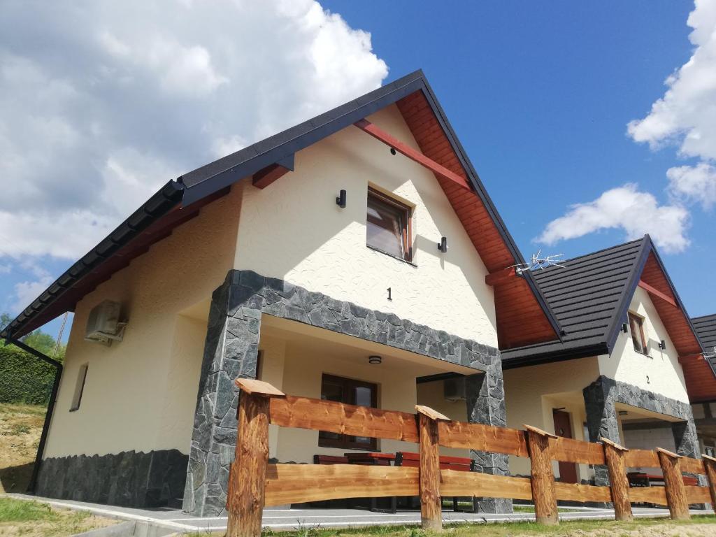 una casa con techo negro en Domki letniskowe KAMA Polańczyk 514-280-102 en Solina
