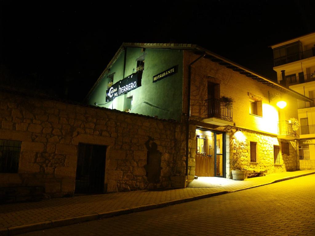 een bord aan de zijkant van een gebouw 's nachts bij La Casona del Herrero in Navaleno