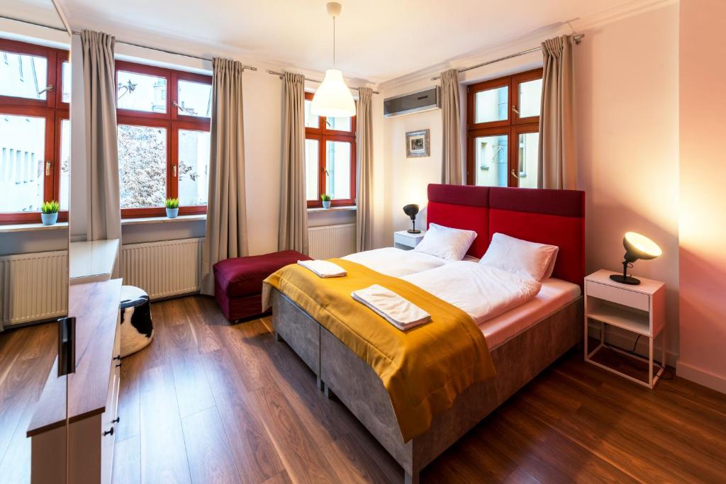 1 dormitorio con 1 cama grande y cabecero rojo en TCZ Mokra, en Poznan