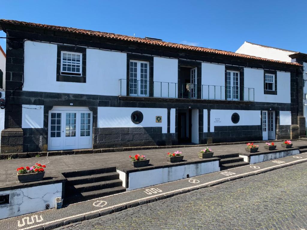 un gran edificio blanco con flores delante en Casa das Barcas - TH, en São Roque do Pico