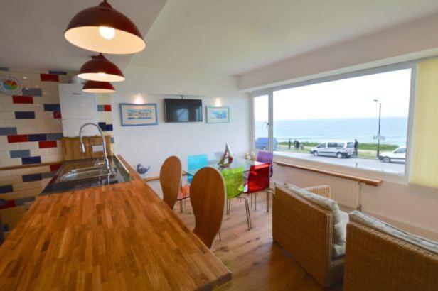 a dining room with a table and a view of the ocean at Foreshore at Fistral in Newquay