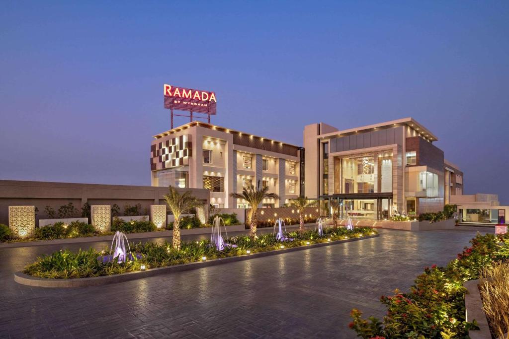 a building with a fountain in front of it at Ramada by Wyndham Gandhidham Shinay in Gandhidham