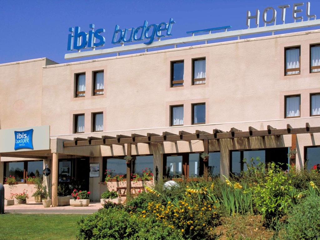 een gebouw met een bord aan de voorzijde van het hotel bij ibis budget Narbonne Sud A9/A61 in Narbonne