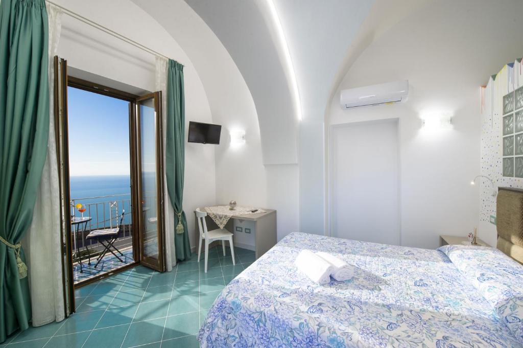 una camera con letto e vista sull'oceano di Domus Caterina a Furore