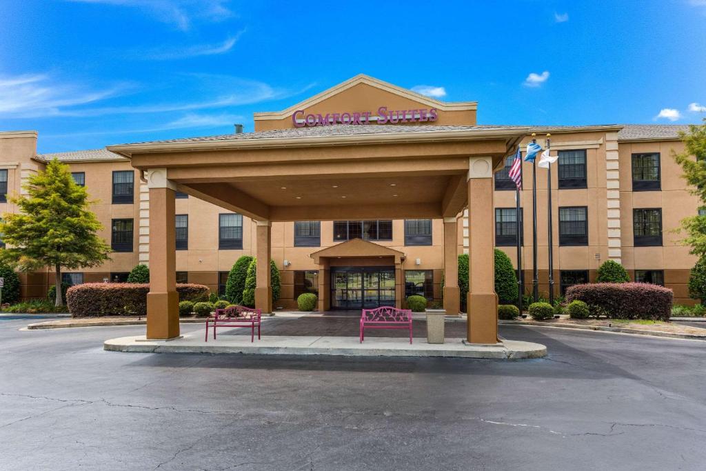 un hotel con dos bancos rosas frente a un edificio en Comfort Suites Monroe, en Monroe