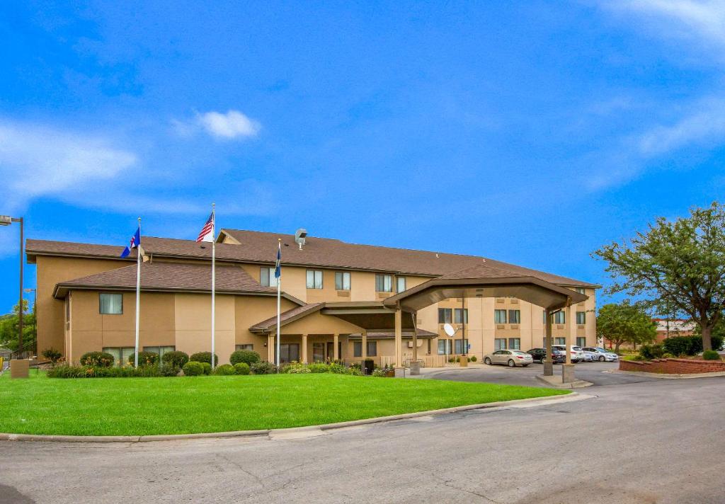 un hotel con banderas frente a un edificio en Quality Inn & Suites Lawrence - University Area en Lawrence