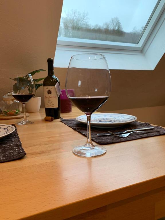 una copa de vino en una mesa de madera en DIE Mansarde !, en Saarbrücken