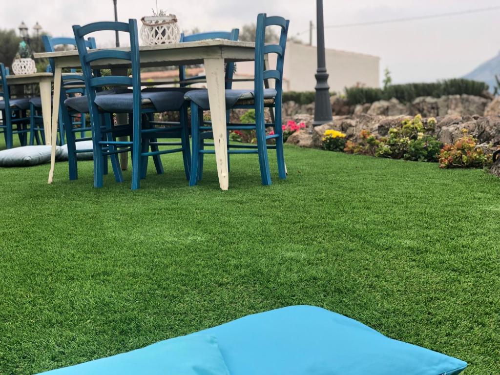 una mesa y sillas en un césped con alfombra azul en Country House S'Ozzastru en Dorgali