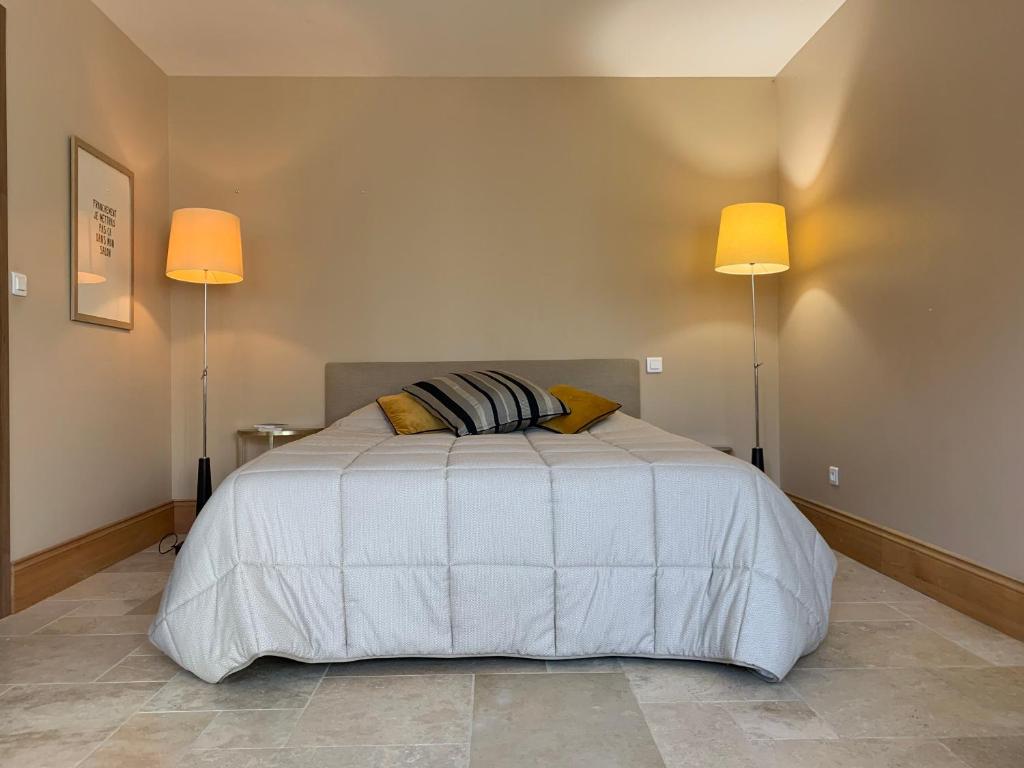 ein Schlafzimmer mit einem weißen Bett mit zwei Lampen in der Unterkunft STUDIO EN VILLE ET CAMPAGNE in Louhans