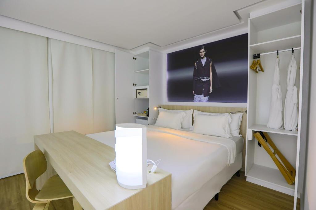 una camera da letto con un grande letto bianco e un tavolo di Bossa Nova Ipanema a Rio de Janeiro