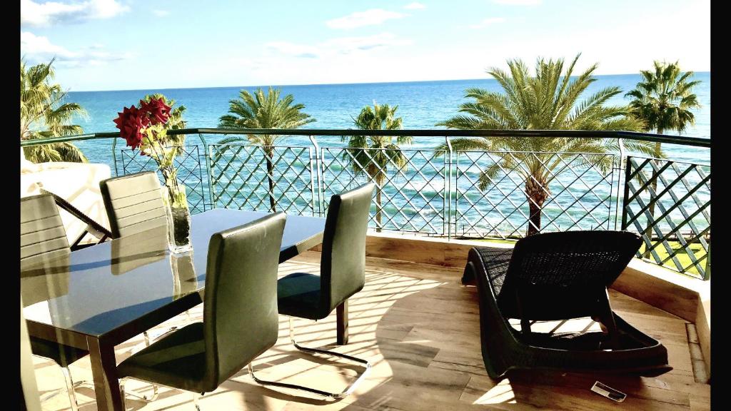 uma varanda com uma mesa e cadeiras e o oceano em MI CAPRICHO B17 Beachfront Apartment em Mijas Costa