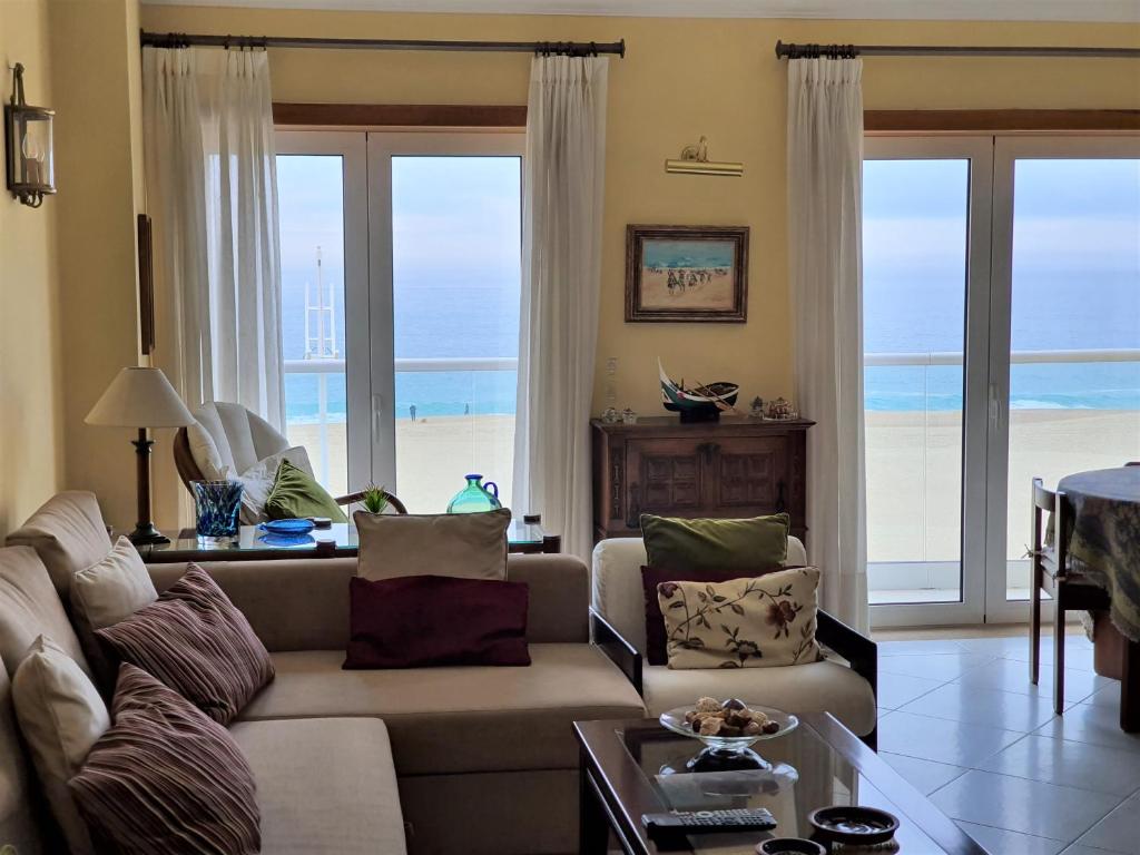 ナザレにあるNazare apartamento em frente ao marのリビングルーム(ソファ付)が備わり、海の景色を望めます。