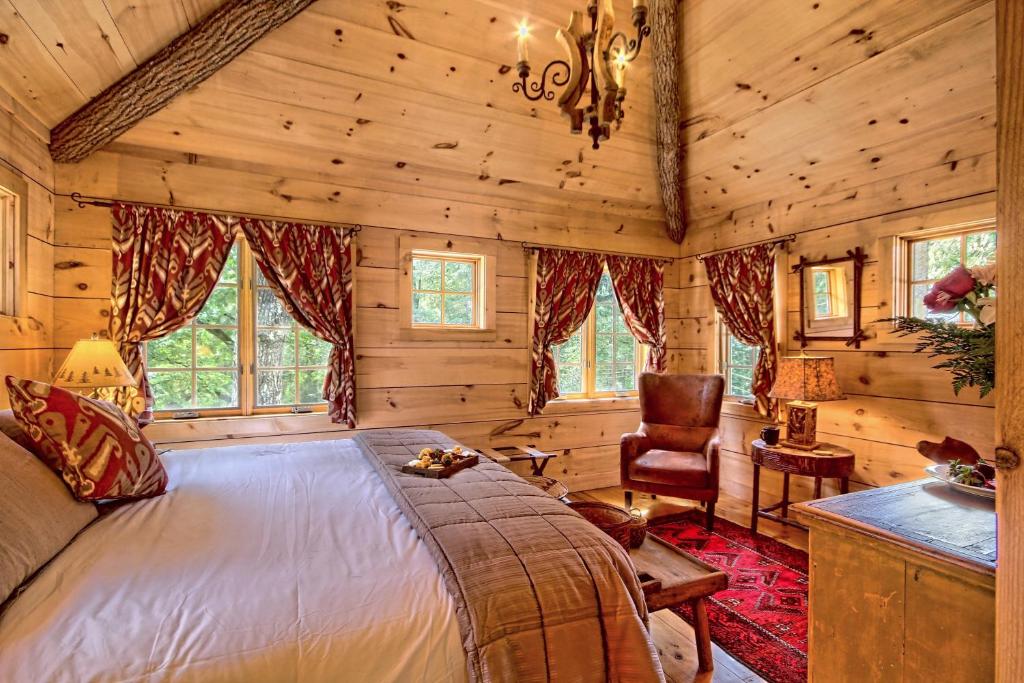 a bedroom in a log cabin with a bed and a chair at Lake Rabun Hotel in Lakemont