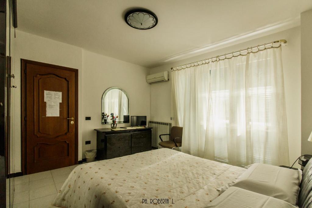 1 dormitorio con 1 cama y reloj en la pared en Profumo di Mare free parking included en San Remo