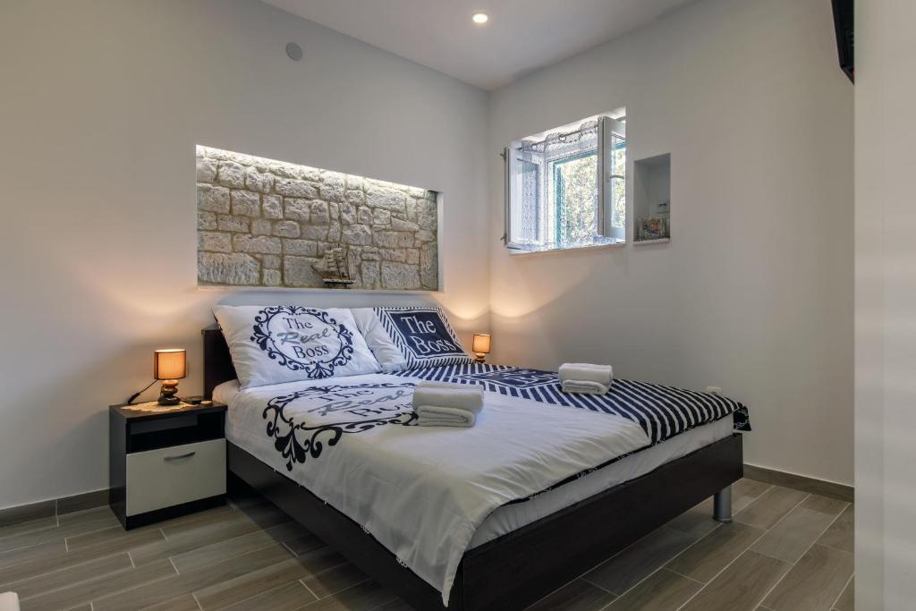 1 dormitorio con 1 cama extragrande y pared de piedra en Apartments Stella Spalato, en Split