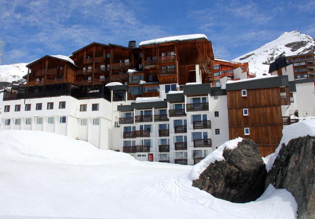 een gebouw in de sneeuw voor een berg bij Hotel Le Val Chavière in Val Thorens