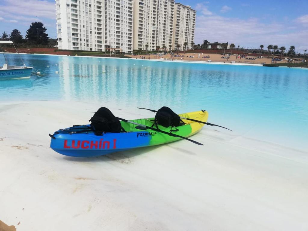 - un kayak assis sur la plage au bord de l'eau dans l'établissement Departamento Laguna Bahía 808 Velero, à Algarrobo