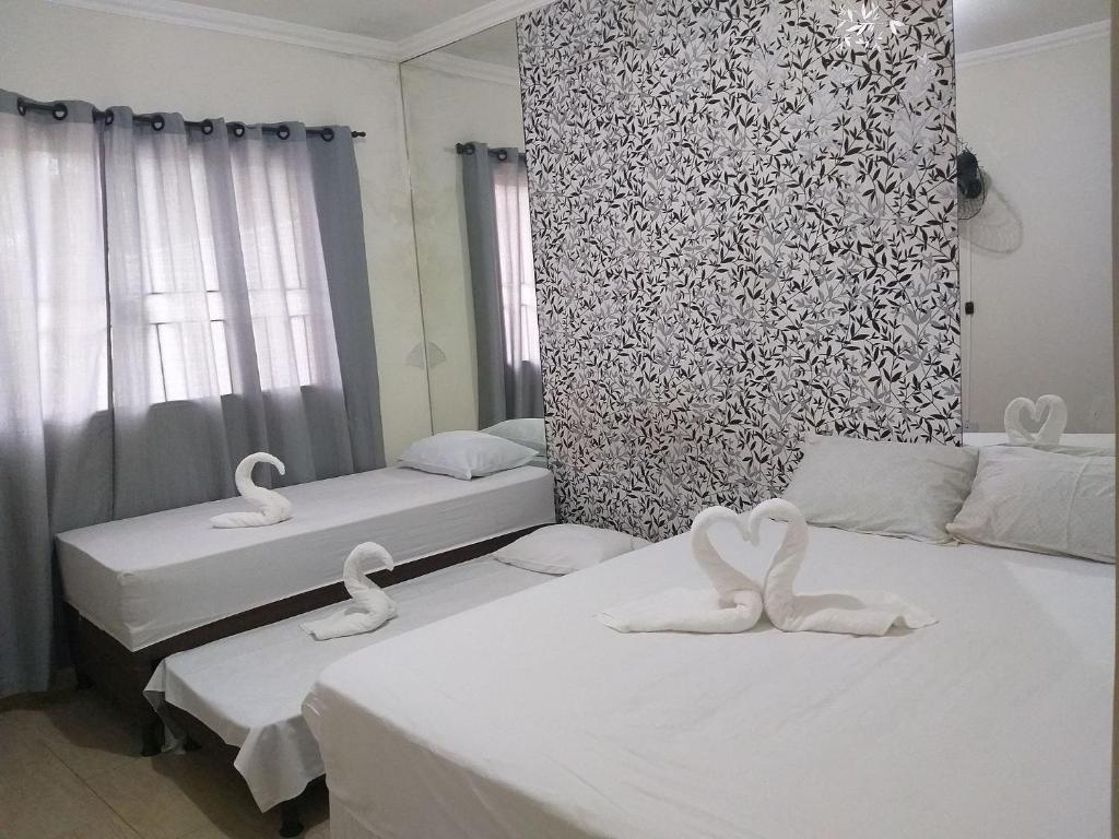 duas camas num quarto com cisnes em Residência Cidade Verde 4 em Maringá