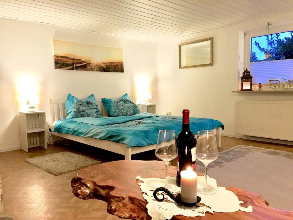 a room with a bed and a table with a bottle of wine at Romantikgarten in Amelinghausen