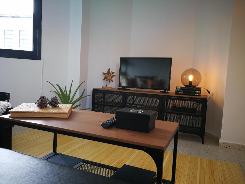 a living room with a table and a tv at Apartamento playa de Levante in La Línea de la Concepción