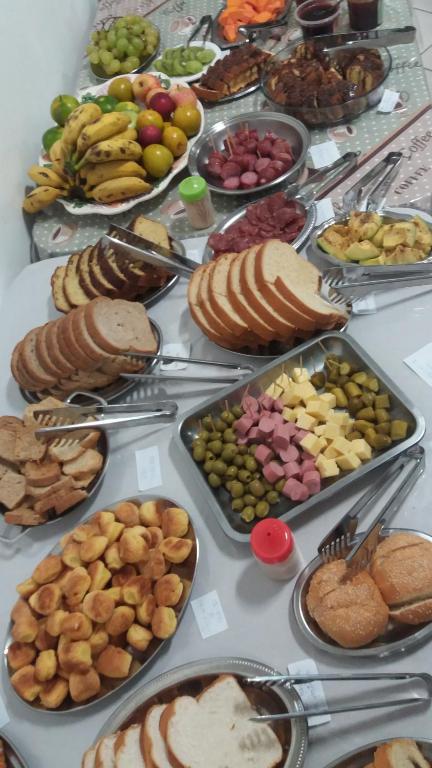 een tafel met veel verschillende soorten voedsel erop bij Hotel Pousada Rolantchê in Rolante