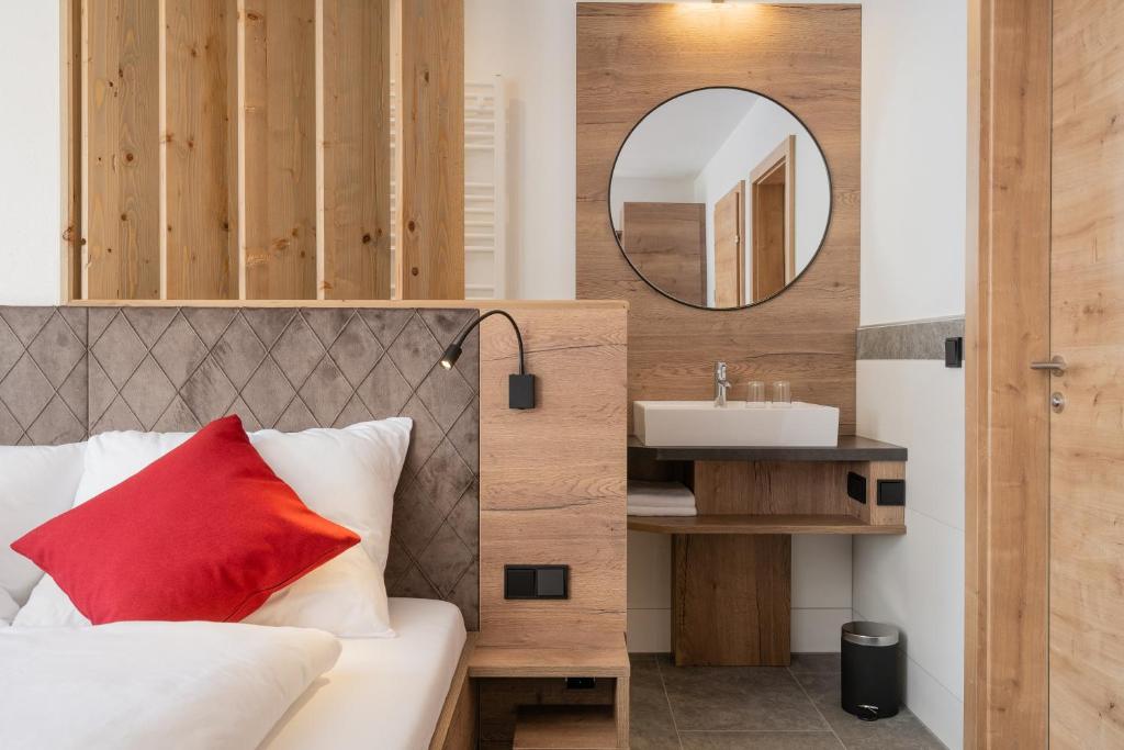 a bedroom with a bed with a mirror and a sink at Bergappartements Pröll in Kleinarl