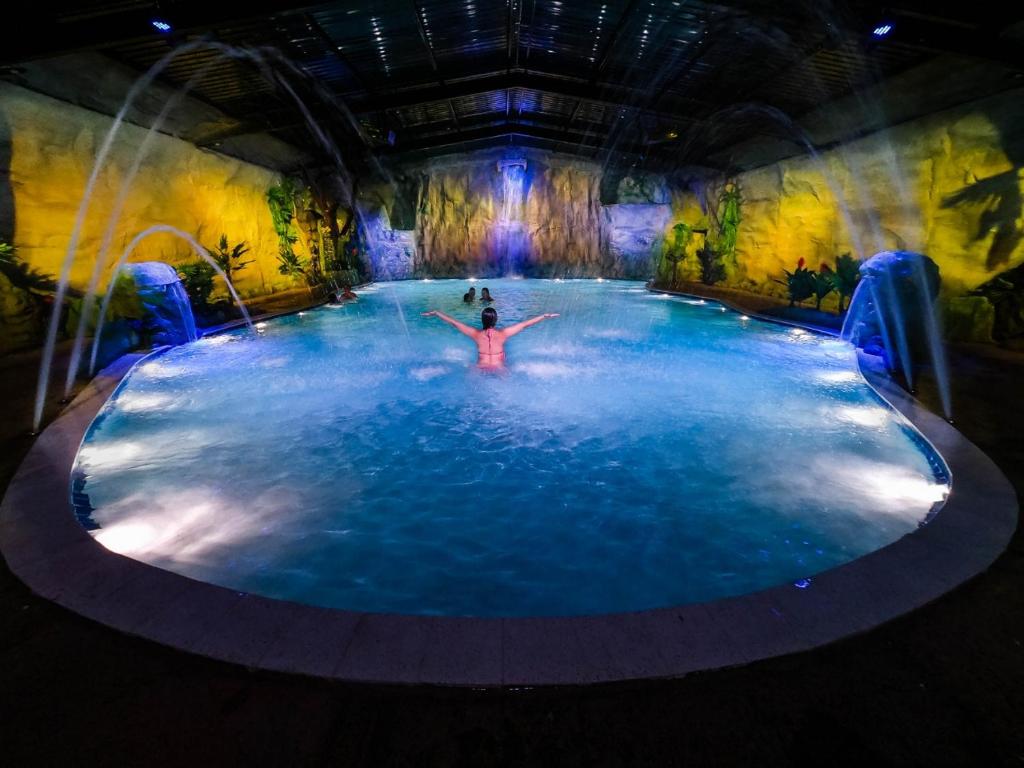 una grande piscina d'acqua con una persona di Brotas Eco Hotel Fazenda a Brotas