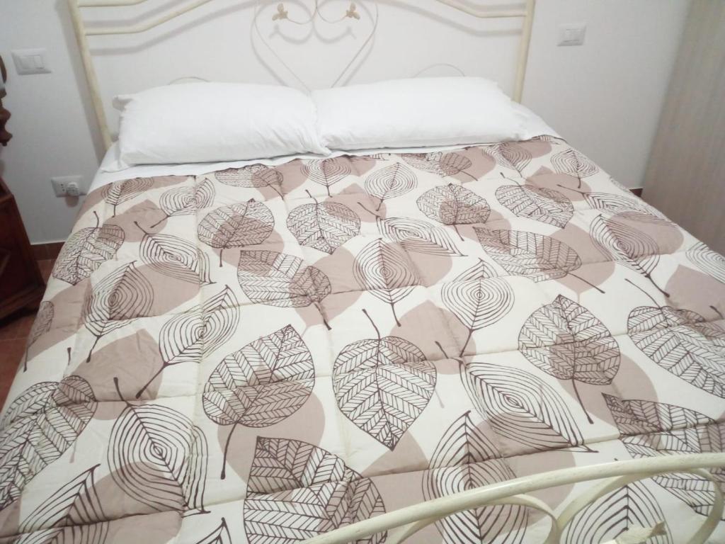 Una cama con una manta marrón y blanca. en U’ Fore B&B Relax garden, en Noci