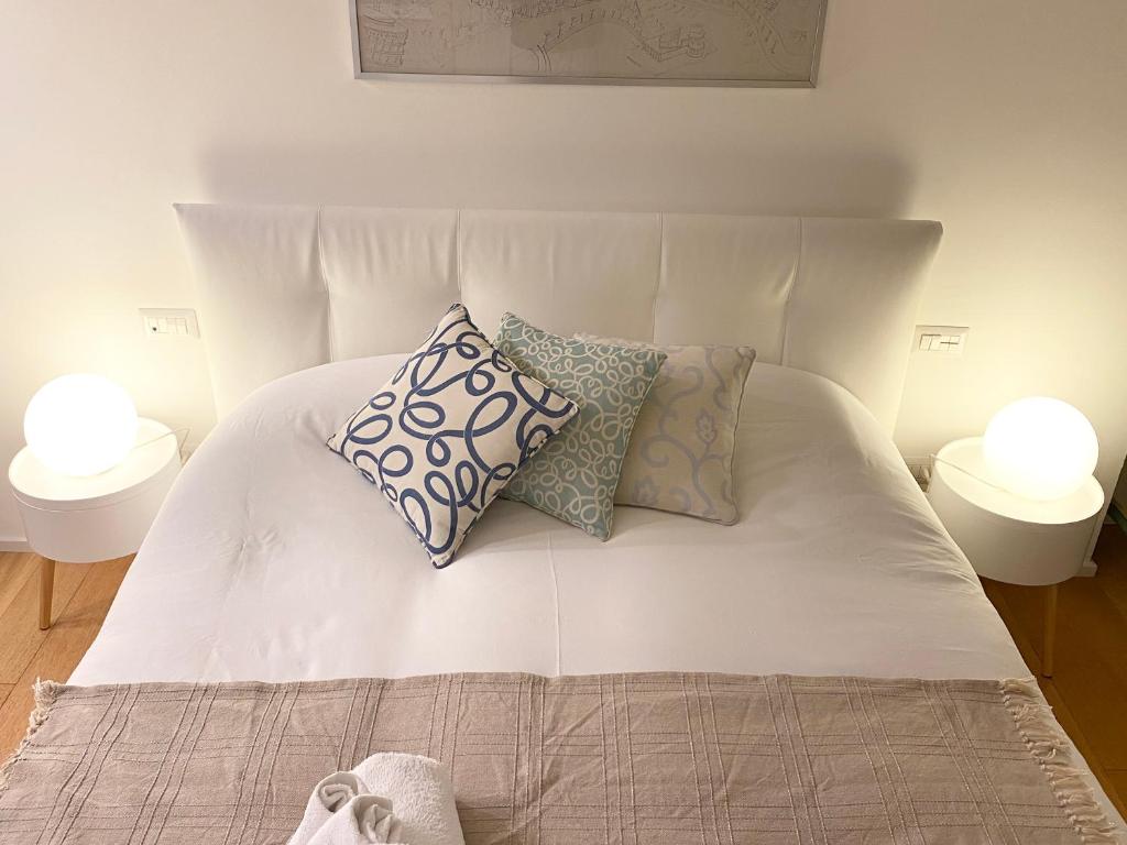 Una cama blanca con almohadas encima. en Repubblica One Room Apartment, en Milán