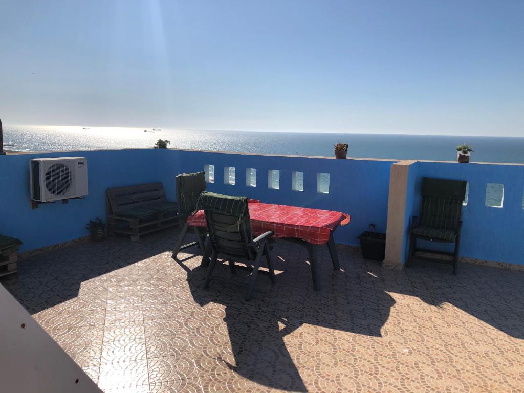 - une table et des chaises sur une terrasse donnant sur l'océan dans l'établissement Atlantica-Home, à Aourir