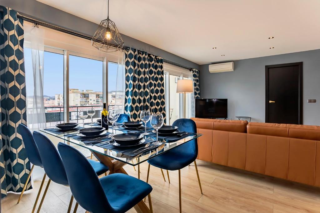 ein Esszimmer mit einem Tisch und blauen Stühlen in der Unterkunft Apartamento Superior Bali in Málaga