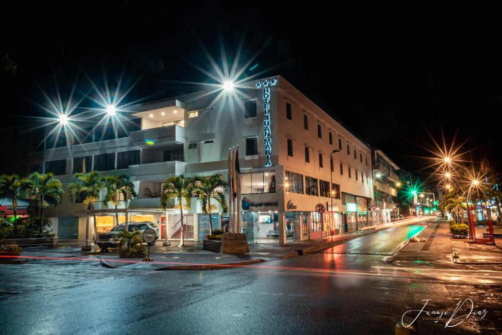 una calle de la ciudad por la noche con luces de la calle en Hotel Juan Maria, en Tuluá