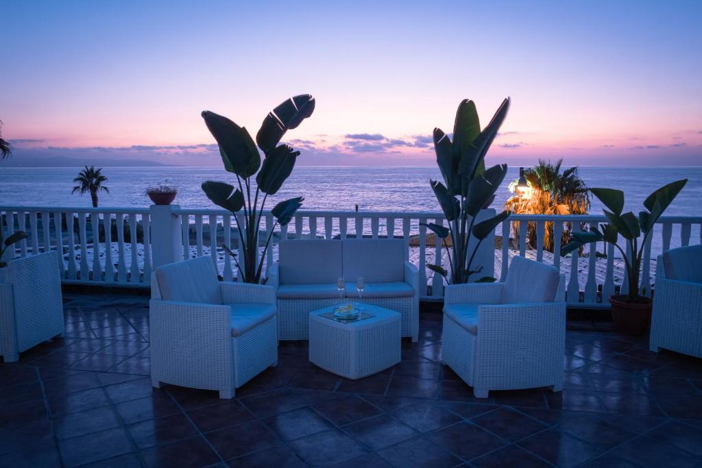 a patio with chairs and a view of the ocean at Eneide in Palmi