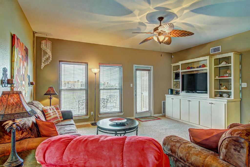 a living room with a couch and a ceiling fan at Snow Condos in Padre Island