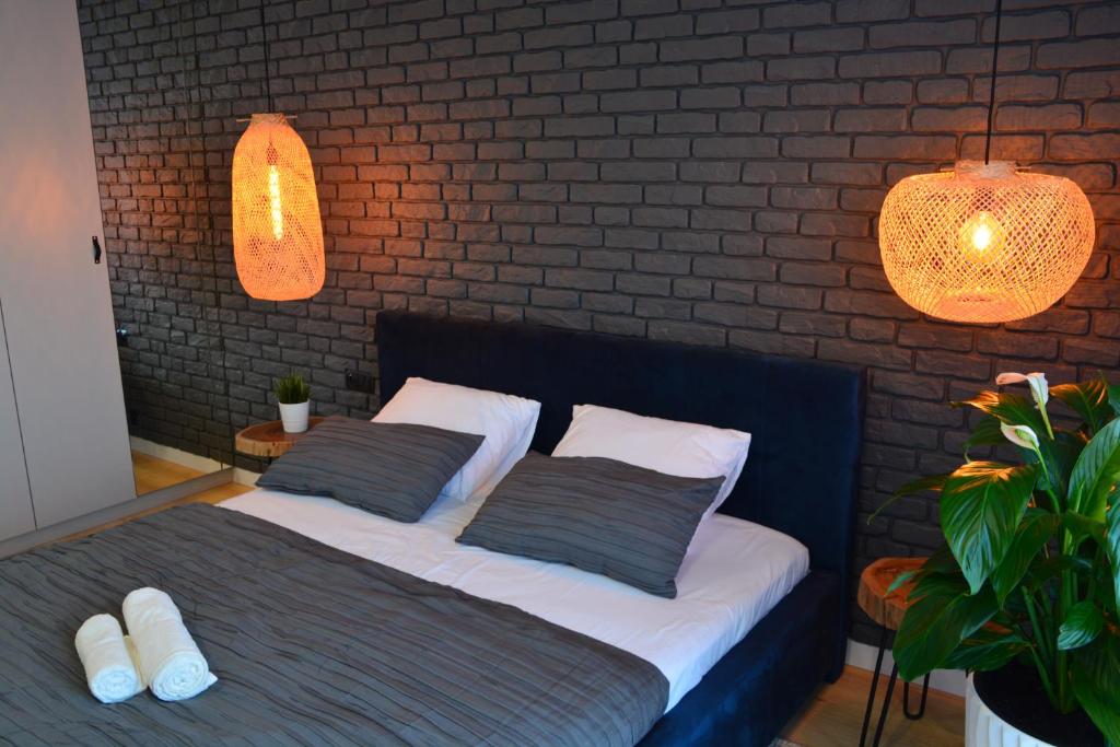 a bedroom with a bed with two pillows and a brick wall at Last Floor Apartment - Krakow City Center close to Old Town in Krakow