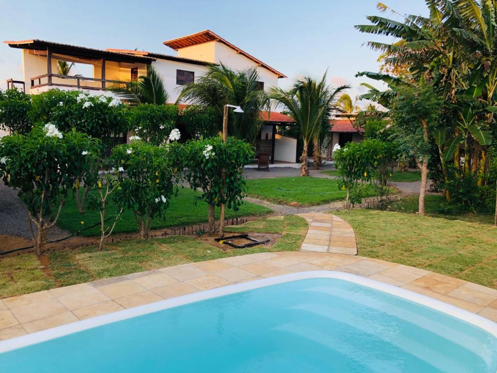 a swimming pool in front of a house at Tropicana Village in São Miguel do Gostoso