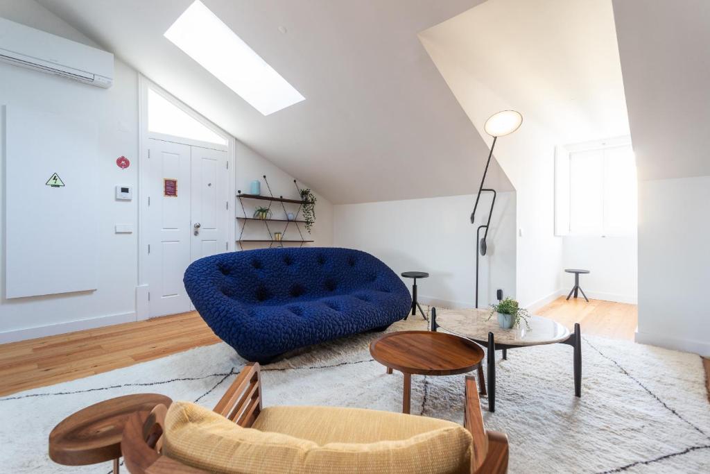 - un salon avec un canapé bleu et une table dans l'établissement FLH Martim Moniz Trendy Flat, à Lisbonne