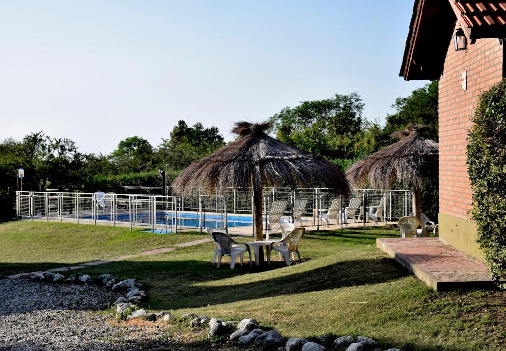 - une piscine avec une table, des chaises et un parasol dans l'établissement Cabañas Babin Kuk, à Merlo