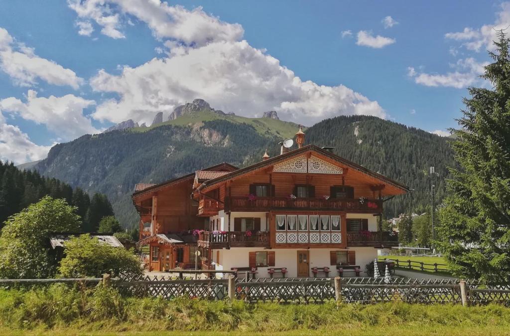 un grande edificio con una montagna sullo sfondo di B&B Agriturismo Cèsa Ciasates a Canazei