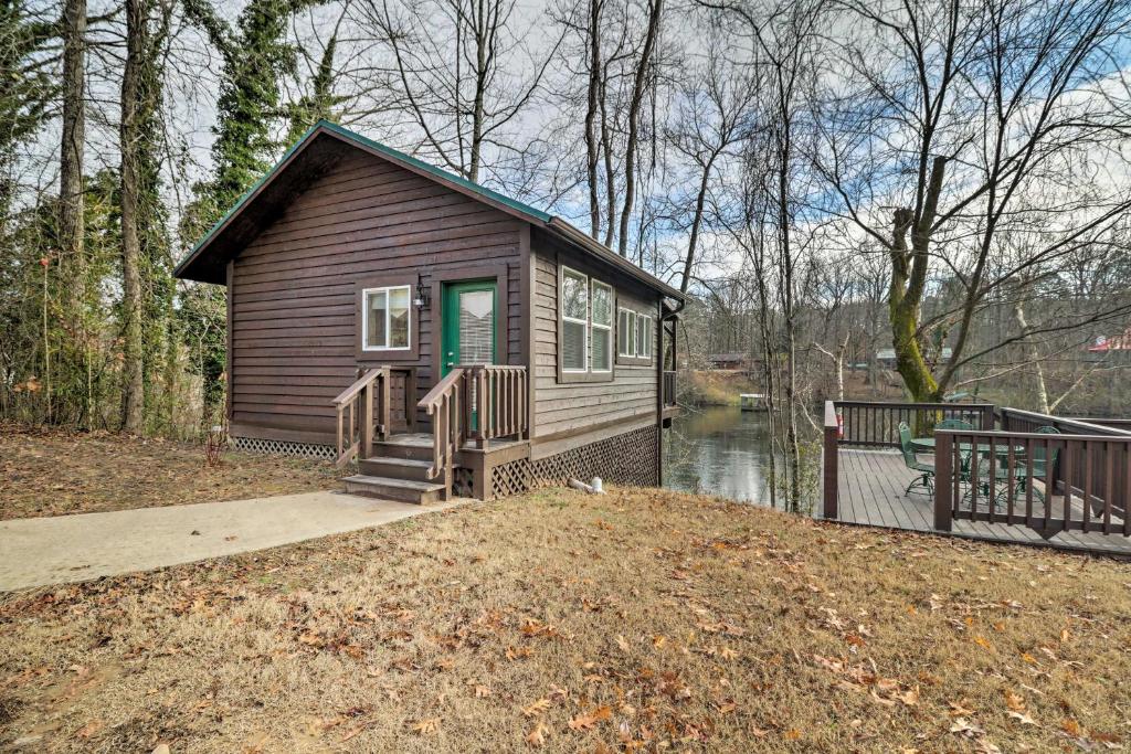 eine kleine Hütte im Wald mit einem Dock in der Unterkunft Cozy Heber Springs Cabin with Deck and Dock! in Heber Springs