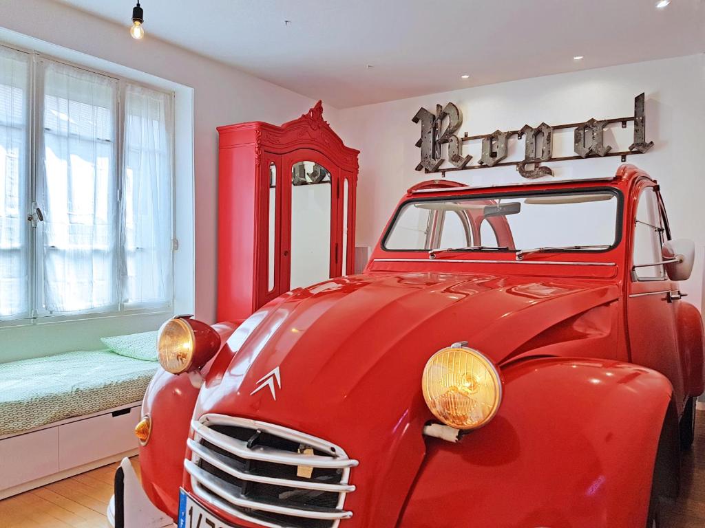 パリにあるBonjour Parisのベッド付きの部屋に停めた古い赤い車