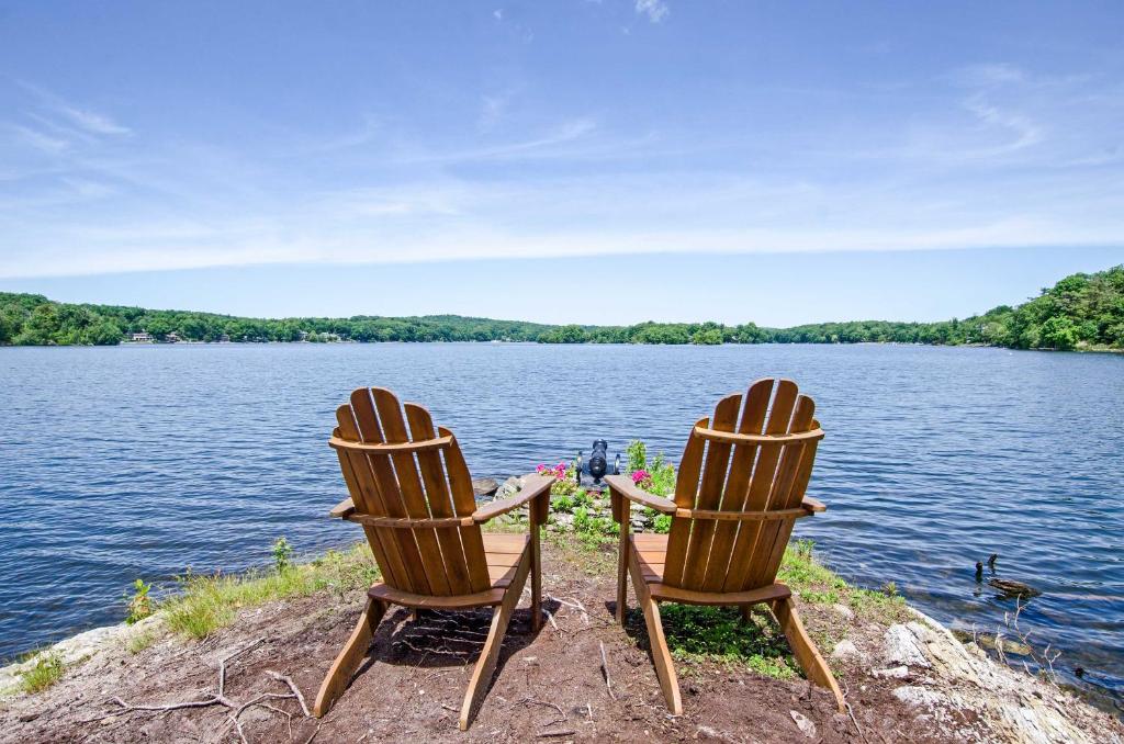 duas cadeiras sentadas na margem de um lago em The Point on Highland Lake Near Mtn Creek Resort em Highland Lakes