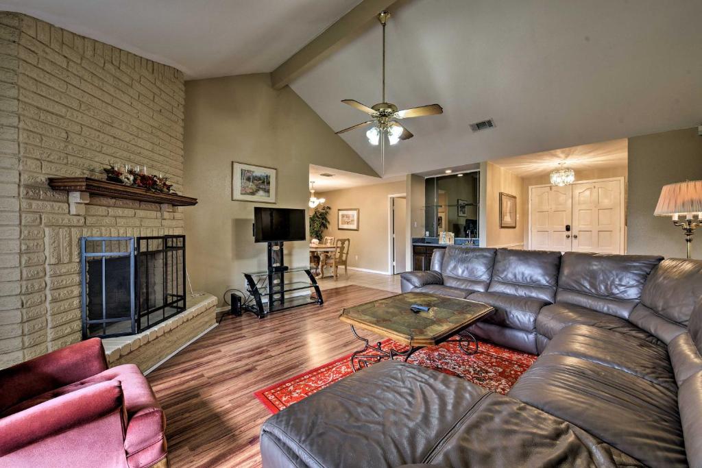 a living room with a leather couch and a fireplace at Pet-Friendly Missouri City Home with Fenced-In Yard! in Missouri City