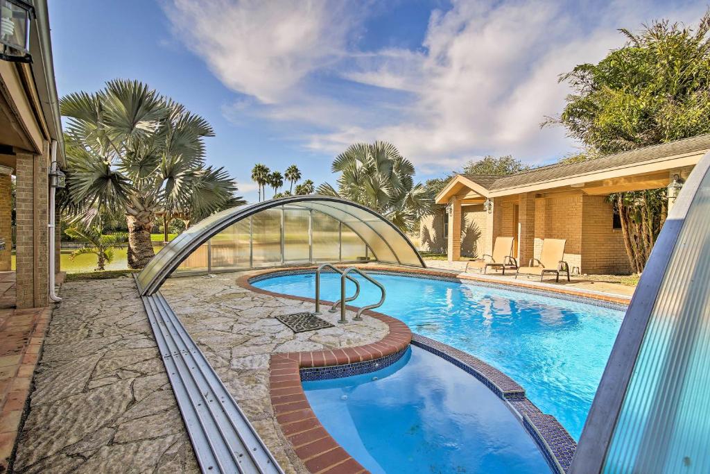 a swimming pool with a bridge over it at Waterfront Harlingen Home with Pool, Patio and Gazebo! in Harlingen