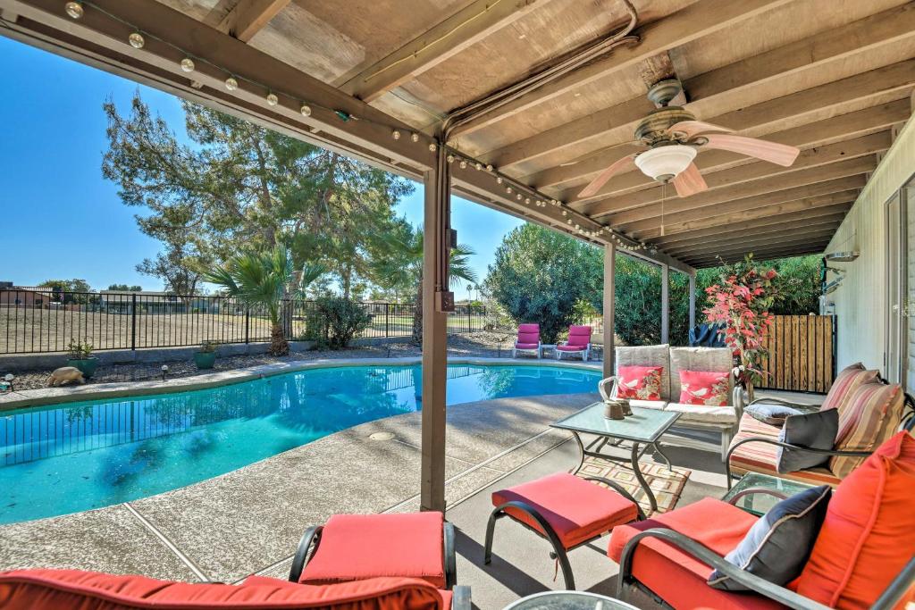 a patio with chairs and a swimming pool at Mesa Home with Pool about 7 Mi to Riparian Preserve! in Mesa