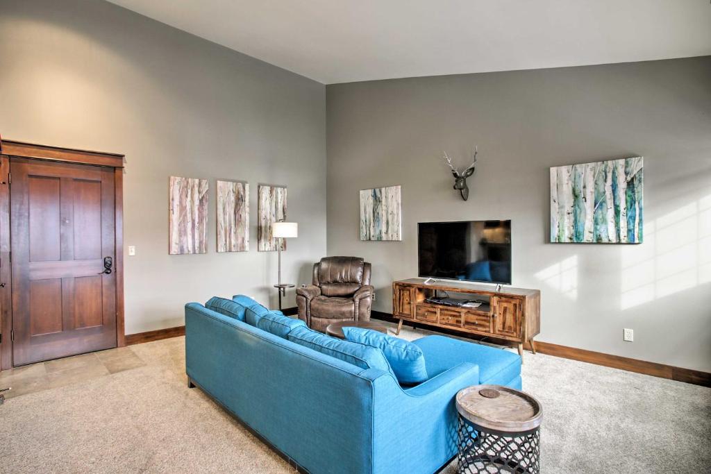 a living room with a blue couch and a television at Coeur dAlene Condo - 2 Mi to Beach and Lake! in Coeur d'Alene