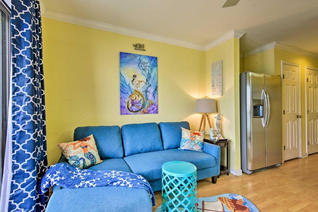 een woonkamer met een blauwe bank en een koelkast bij Corpus Christi Beachfront Condo with Pool Access! in Corpus Christi