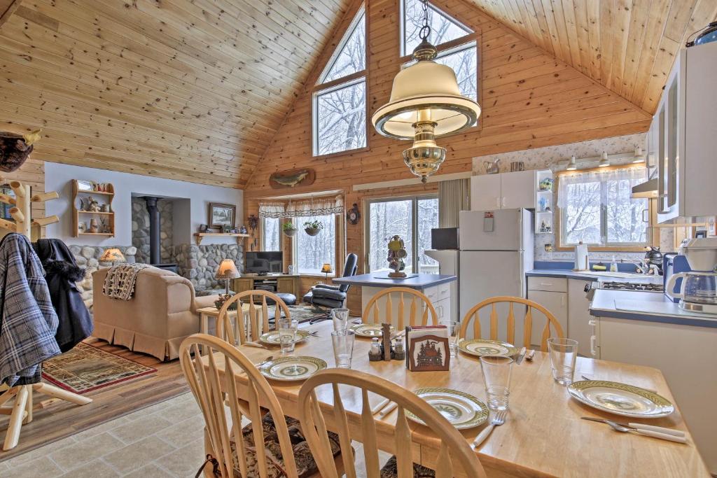 comedor y cocina con mesa y sillas en Cozy Cabin on 10 Acres, Walk to Chippewa River! en Weirgor